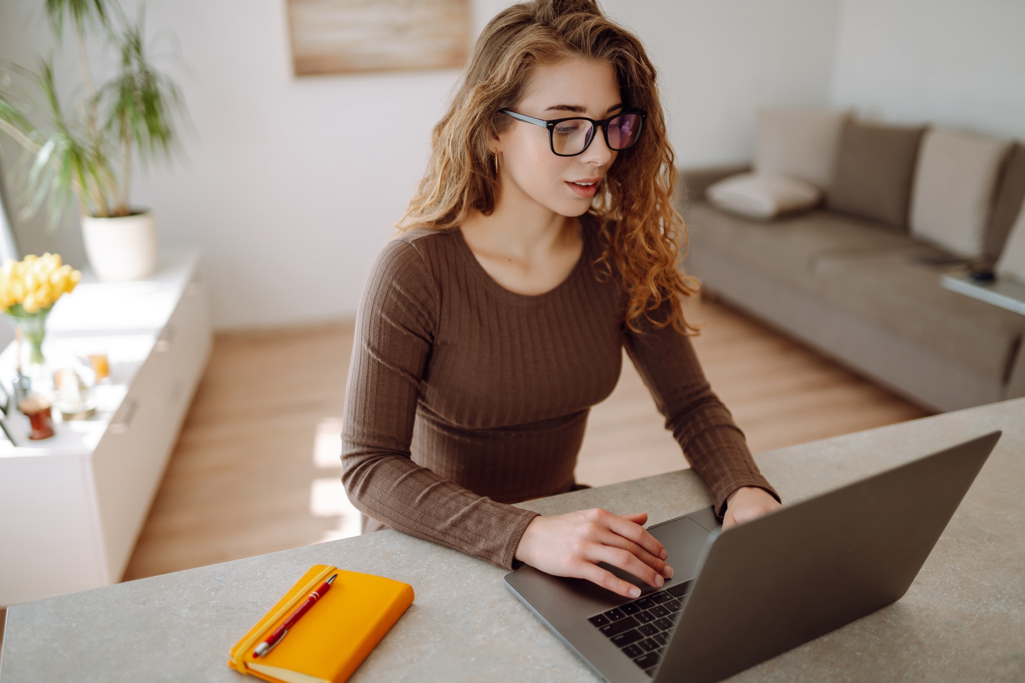 Business woman in casual clothes works with a laptop and notepad. Concept of education, freelancing.